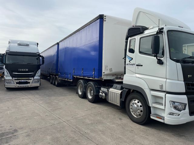 An All Freight Carrying prime mover coupled to two curtainsider trailers for overnight linehaul